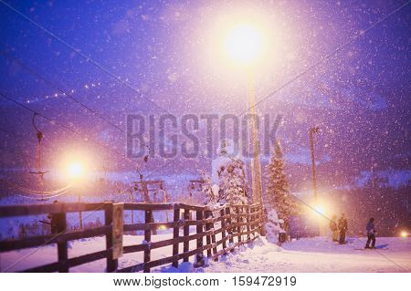 Beautiful cold mountain view of ski resort, winter day with slope, piste and ski lift, evening twilight night picture