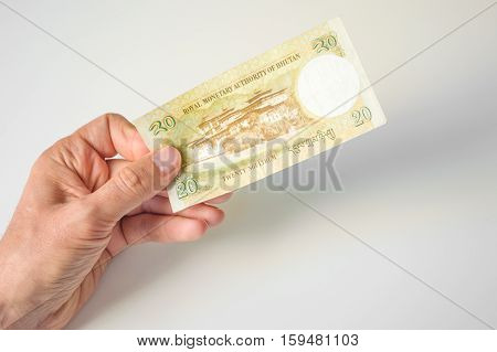 Man Holding Twenty Bhutanese Ngultrum Banknote In His Hand
