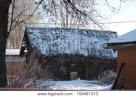 old decripit house from massive woodern bars under roof covered snow lost home in village