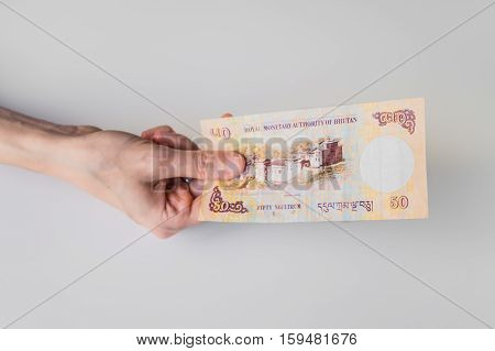 Woman Holding Fifty Bhutanese Ngultrum Banknote In Her Hand