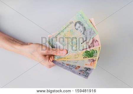 Woman Holding A Bunch Of Bhutanese Ngultrum Banknotes In Her Hand