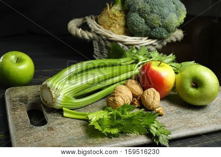 Ingredients for Waldorf salad - celery apples walnuts - fresh and healthy vegetables on granite board.