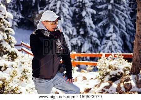 Man Drinks Tea In Cold Winter Forest With Snow