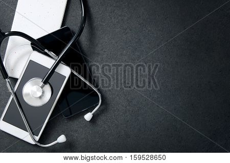 Smartphones and a stethoscope on the desk. Concept of diagnose faults in the phone