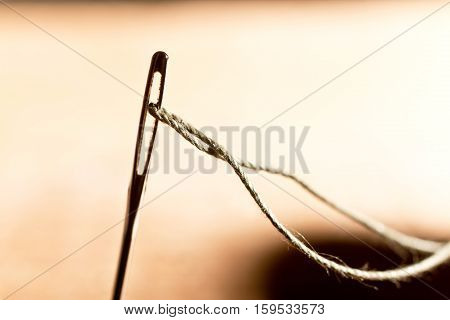 detail of a needle with thread in the workroom shallow depth of field