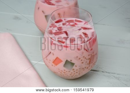 Buko Salad drink in a glass on a green painted wood background.