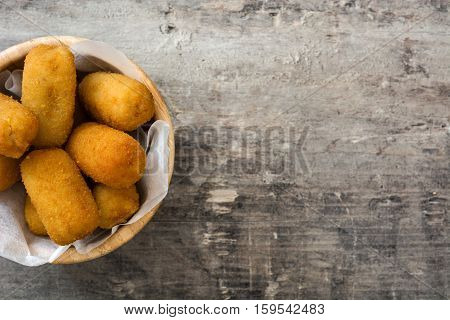 Traditional fried Spanish croquetas (croquettes)  in bowl on wooden background