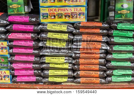 Nilgiri Hills India - October 25 2013: closeup of stack of different Nilgiri Hills Teas on the counter of a stall along the road. Bright colored labels tell name of teas. Plastic bags filled with tea kernels.