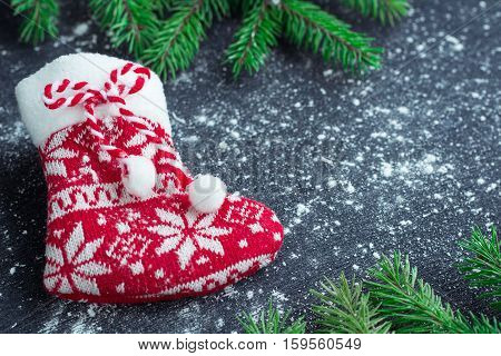 Christmas Red Stocking On Snowbound Black Background With Fir Branches