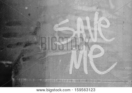 Save me message. Request for help written in water fogged glass.