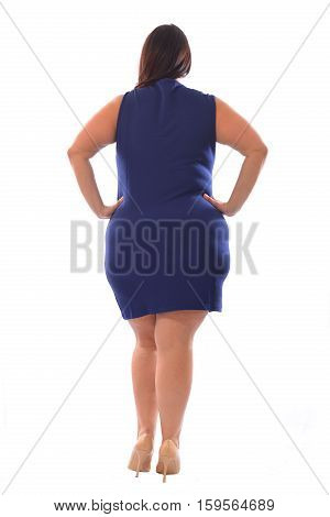 Full-body portrait of plus size model woman wearing XXL blue dress posing isolated on white background. View from the back.