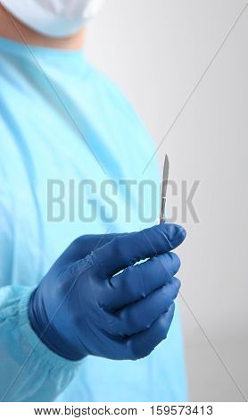 Surgeon hand hold scalpel and tweezers while cut and cure wound closeup. Resuscitation and or, injury heal, medic shop or store, saving patient, 911, surgery and emergency, put stitch concept