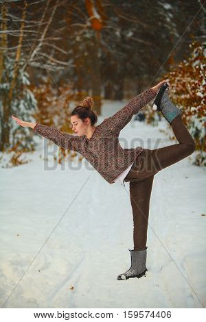 Beautiful Woman Doing Yoga Outdoors In Snow