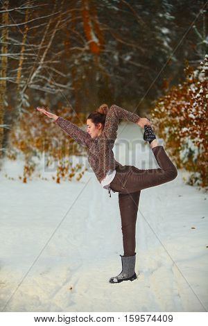 Beautiful Woman Doing Yoga Outdoors In Snow