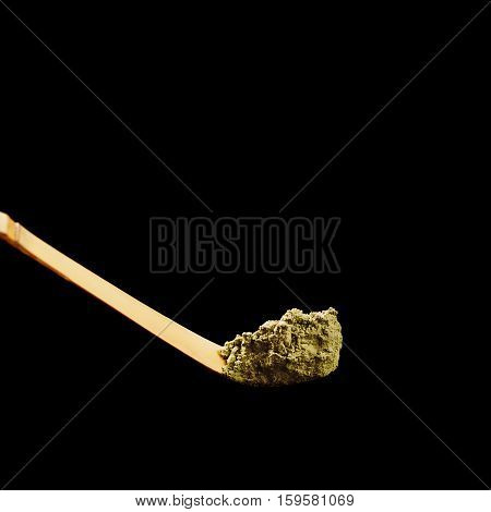 Special bamboo spoon for green powdered matha tea isolated on black background.