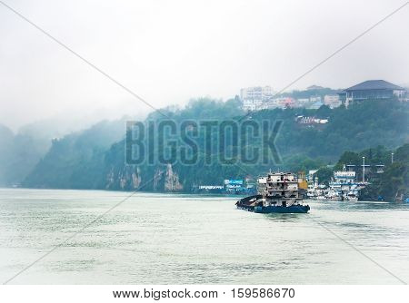 Cargo ship cruising on Yangtze river in rainy day