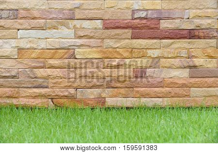 Exterior Brick Wall texture background with grass.