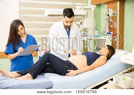 Doctor And Nurse Examining Pregnant Woman