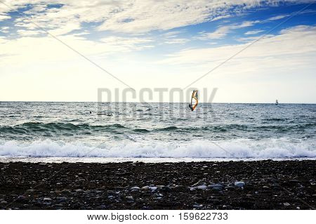 Group of windsurfers on boards in wavy sea. Lifestyle and sport completition concept. Group of people. Fun and leisure activity.