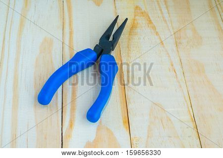 Blue pliers on wooden background, Tool for service