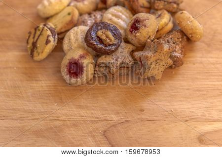 Several christmas cookies on rustic wooden plate with text space