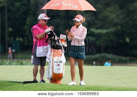 KUALA LUMPUR, MALAYSIA - OCTOBER 29, 2016: Jenny Shin of South Korea checks with her caddie on the fairway of the TPC Golf Course at the 2016 Sime Darby LPGA Malaysia golf tournament.