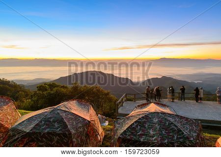 View of morning mist and sun rise at Doi Ang Khang mountain one of the famous mountains in Chiangmai place for camping with tent on winter Chiang Mai Thailand.