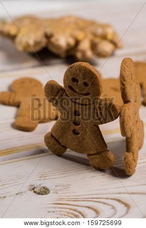 Christmas smiling gingerbread men men and women on rustic wooden background