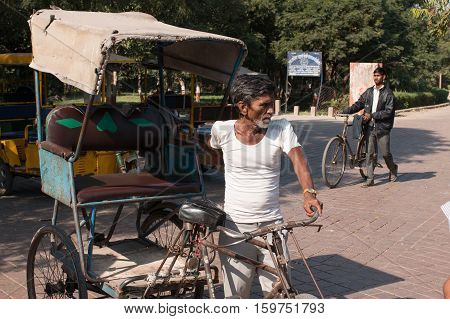 AGRA INDIA - Nov 27 2016: Unidentified men drives pedicab in front of Western Gage of Taj Mahal the monument of love on 27 November 2016.
