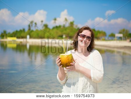 Beautiful woman with coconut on a tropical resort