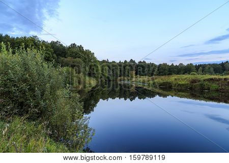 River outside the city, around the field and forest, summer evening