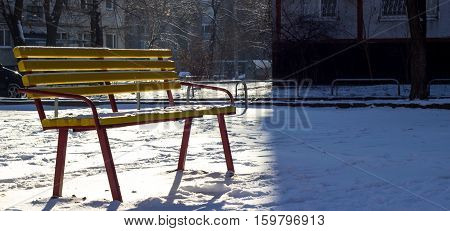 urban yard winter landscape bench lit backlight while the other half of the frame house casts a strong shadow