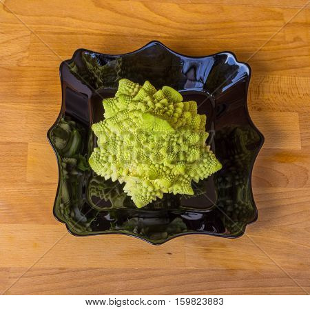 Romanesco broccoli, or Roman cauliflower. Romanesco green broccoli cabbage. Bright green autumn cabbage romanesco on a wooden board.