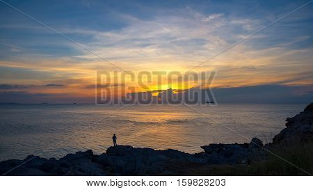 Fishermen standing on the rocks at sunset, Thailand