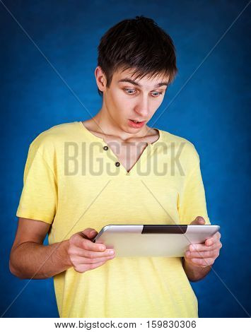 Surprised Young Man with Tablet Computer on the Blue Background