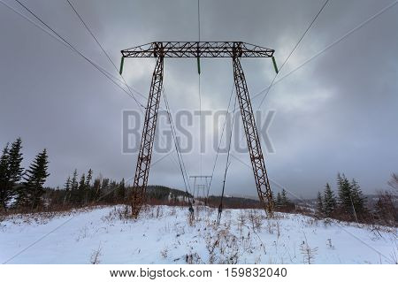 Electricity transmission power lines on winter background (High voltage tower). Metal electricity transmission pylon.