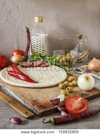 Ingredients Italian pizza. Cooking. Pizza topping. Olive oil and vegetables on a rustic background.