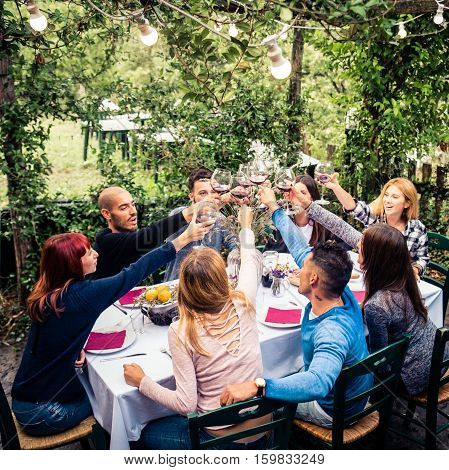 Group of friends at restaurant outdoors - People having dinner in a home garden