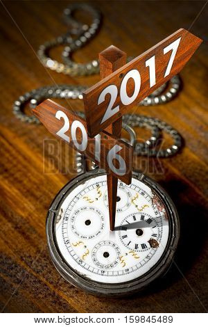 New Year 2017 - Old pocket watch with two wooden signs with arrows and the years 2016 and 2017