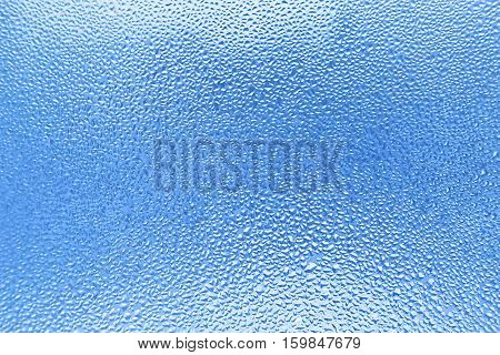 Water drops on glass naural blue background