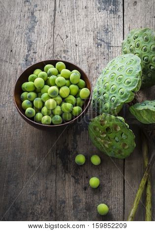 Lotus Seeds In Red Wood Bowl And Calyx On Wood Background