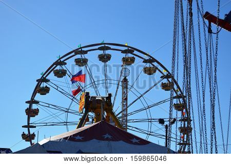 Ferris wheel blue sky swing rope chains flags