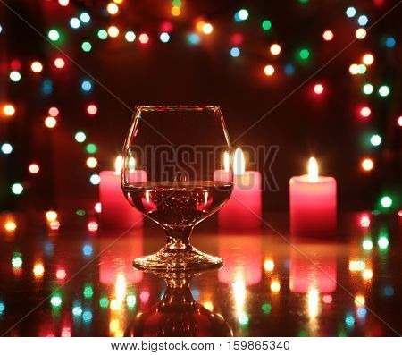 christmas composition photo cognac glass and candle on black background.