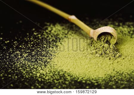 Special bamboo spoon for green powdered matha tea isolated on black background.