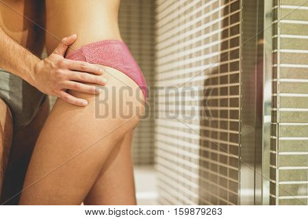 Close up of loving couple getting ready to do shower making foreplay - Young woman and man kissing and having tender moments - Love and sexual concept - Soft focus on man fingers - Warm vintage filter