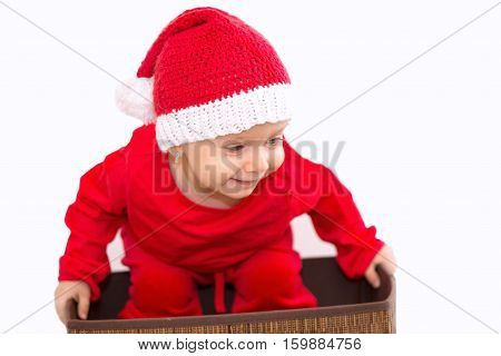 Baby dreesed in Christmas costume wants to enter in the box
