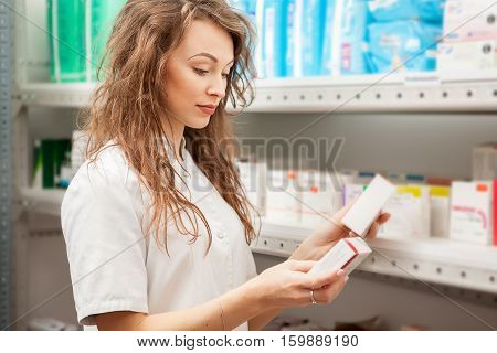 Pharmacist In The Deposit Cheking Some Boxes With Drugs And Pills