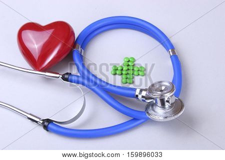 Red heart and a stethoscope on desc.