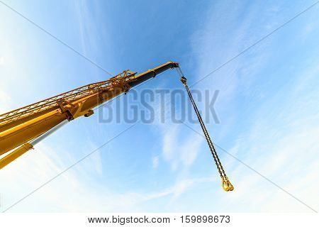 The telescopic boom crane. Against the background of the blue sky.