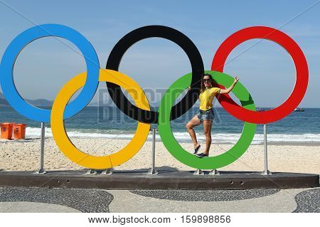 RIO DE JANEIRO, BRAZIL - AUGUST 6, 2016: Brazilian tourist taking picture of Olympic Rings at Copacabana Beach in Rio de Janeiro